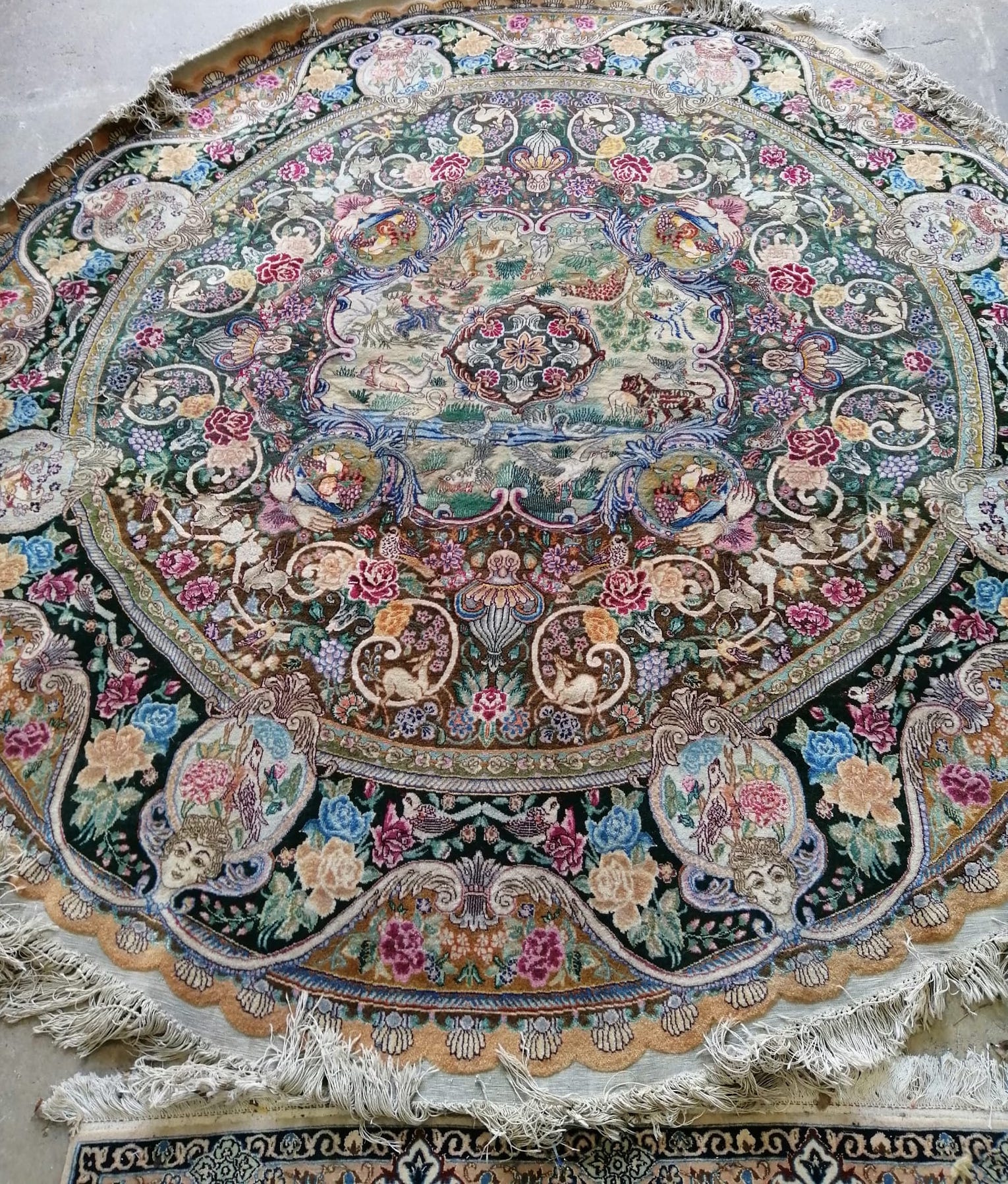 A Tabriz style circular rug woven with animals and birds within panels of fruit and flowers, diameter 220cm